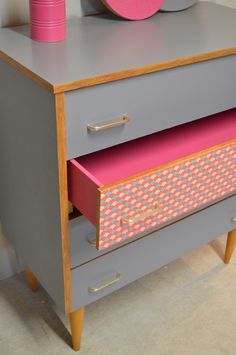 commode grise avec un tiroir en papier peint rose graphique